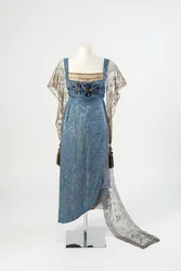 Blue Figured Silk Evening Dress with Gold Net Sleeves and Train Embroidered in Gold Metal Strip and Decorated with Blue Gems and Tassels, 1911